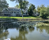 Waterfront view of a completed Long Lake landscape project with custom pool and outdoor living space