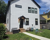 Residential landscape transformation featuring a custom entry stoop and gravel patio in Minneapolis