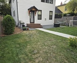 Finished Minneapolis backyard with a compacted gravel patio, entry stoop, and landscaped lawn