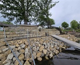 Stone shoreline restoration with retaining wall along Champlin waterfront